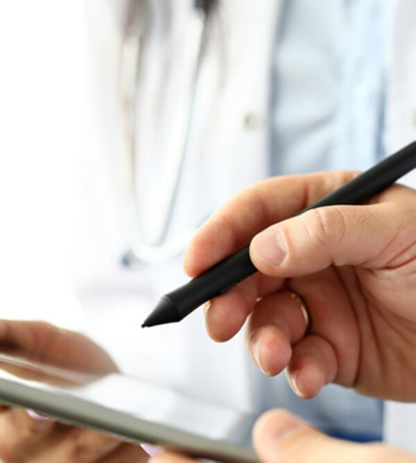 A doctor filling out a form on a tablet