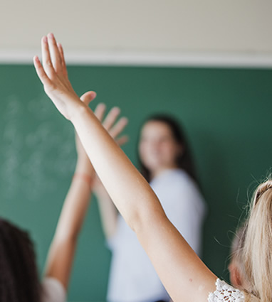 A blurry shot of a teacher showing students hands in the air
