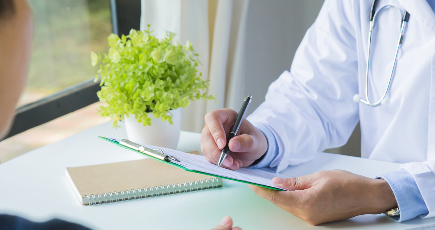 A dcotor taking notes on a clip board