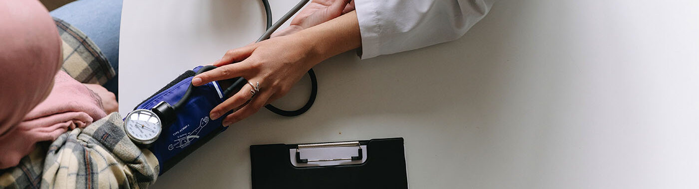 An overhead image of a doctor taking somebodies blood pressure